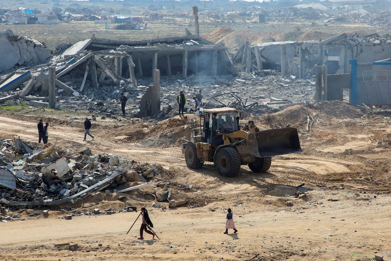 La maquinaria pesada funciona para abrir la carretera y revolver los escombros, en medio de un alto el fuego entre Israel y Hamas, en la tira del sur de Gaza